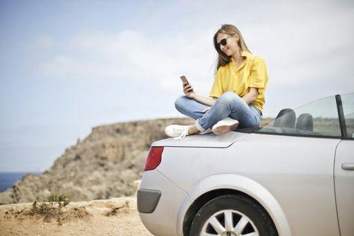 Woman sitting on her car