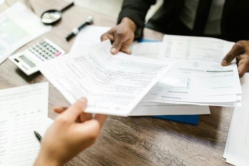 someone handing paperwork to another person